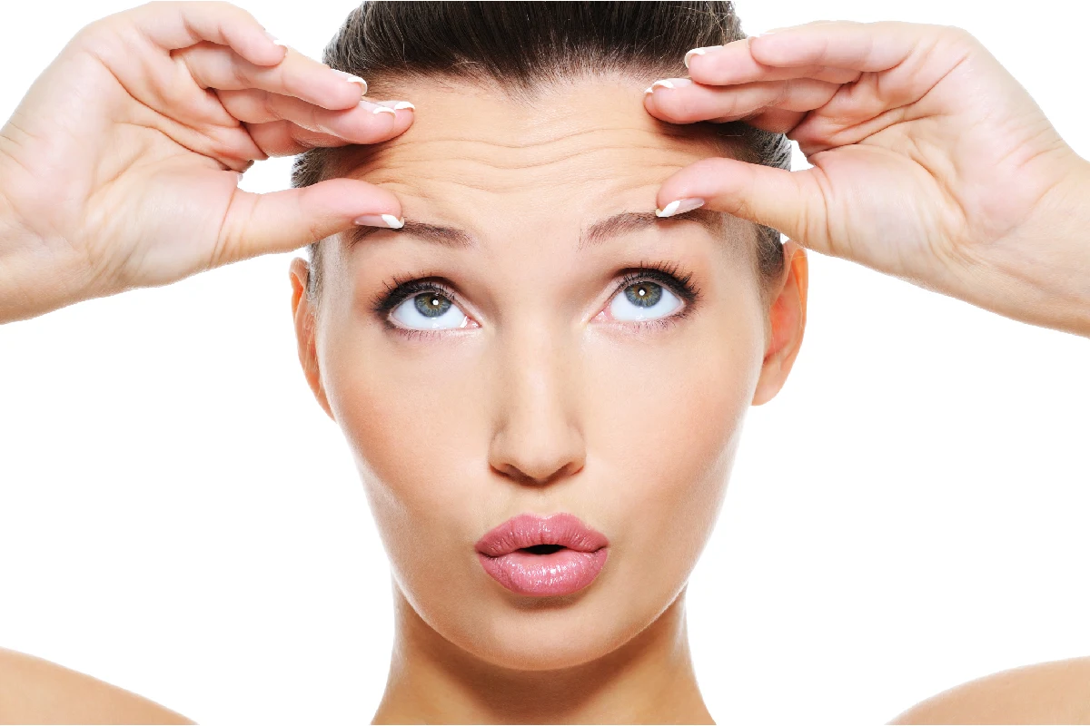 Woman smoothing forehead expression lines with preventative Botox by inSPAration Aesthetics & Wellness